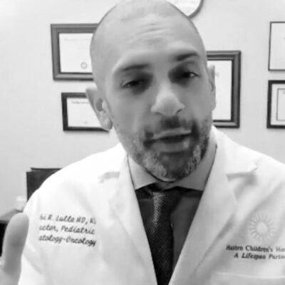 A man in a lab coat is talking to the camera.