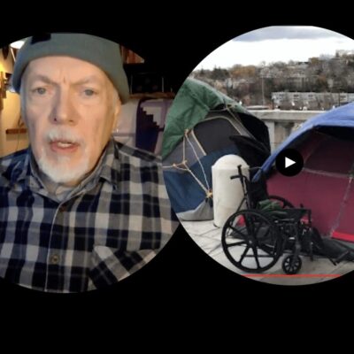 A man in a wheelchair in front of a tent.