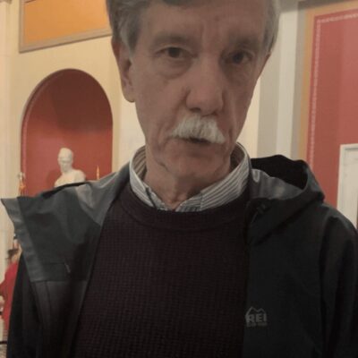 A man with a mustache in a museum.