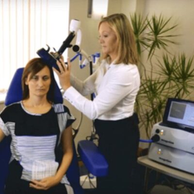 A woman sitting in a chair with a machine on her head.