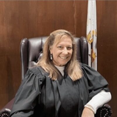 A woman sitting in a judge's chair.