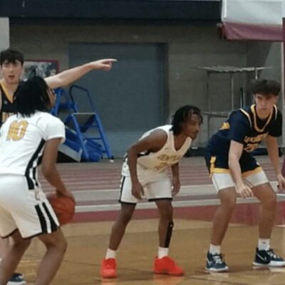 A group of young men playing basketball in a gym.