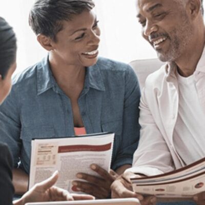 A group of people sitting around a table looking at papers.