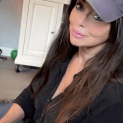 A woman with long hair and a baseball cap.