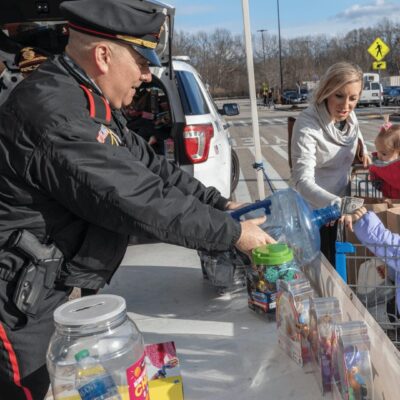 A police officer with a shopping cart.