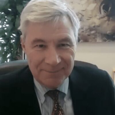 A man in a suit and tie sitting in an office.