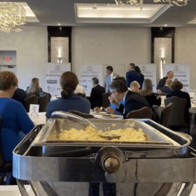 A group of people sitting at tables in a conference room.