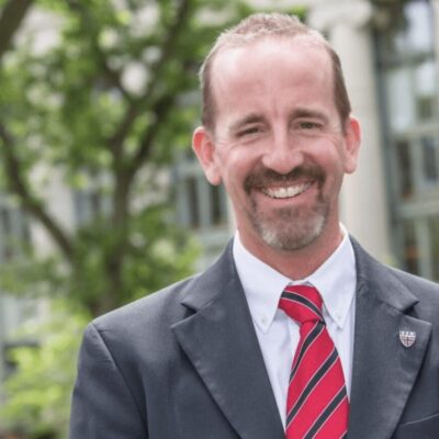 A smiling man in a suit and tie.