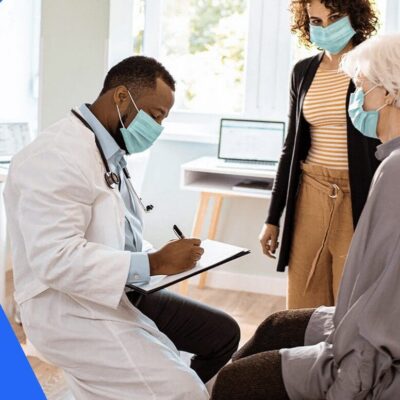 A doctor is talking to an elderly woman wearing a face mask.