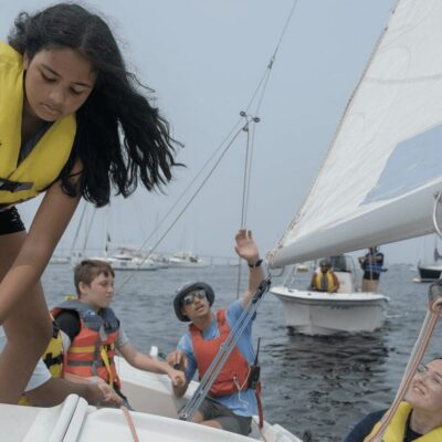A group of young people on a sailboat.