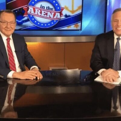 Two men sitting at a desk in front of a news tv discussing Judge Frank Caprio's latest ruling.
