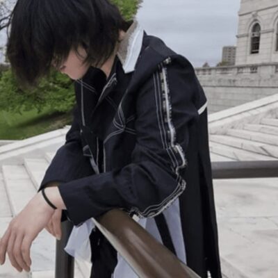 A person leaning on a railing in front of a building.