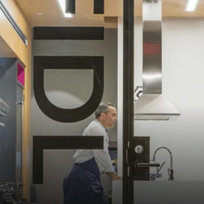 Two men standing in front of a door with a sign that says Johnson & Wales.