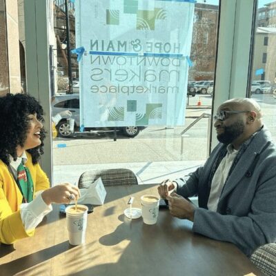 Two people sitting at a table in front of a window.