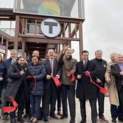 A group of people standing in front of a red ribbon.