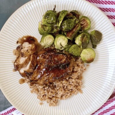 A plate with chicken, brussels sprouts and rice.