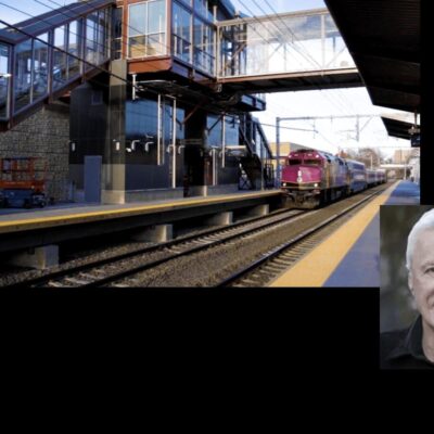 A picture of a man standing next to a train.
