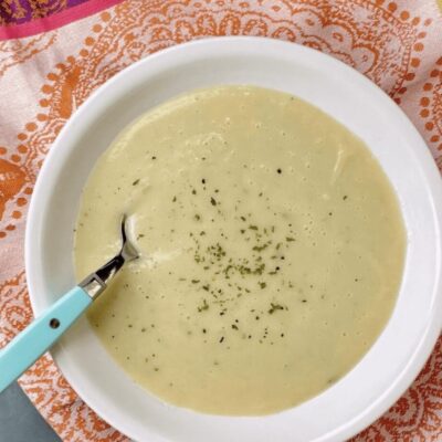 A bowl of soup with a spoon in it.