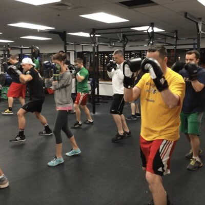 A group of people practicing boxing in a gym.
