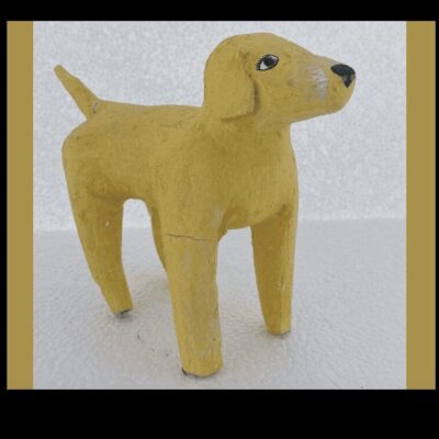 A yellow wooden dog standing on a white surface.