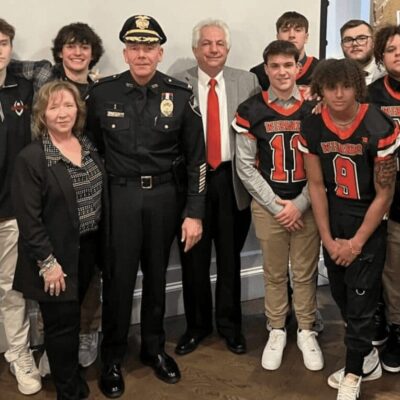 A group of people posing for a photo with a police officer.