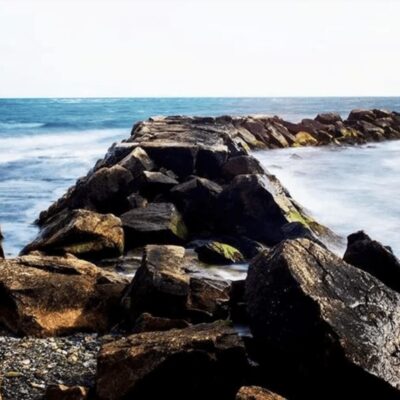 A rocky shore with waves crashing over rocks.