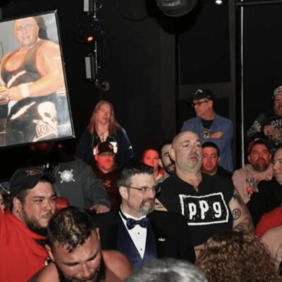 A group of people holding up a picture of a wrestler.