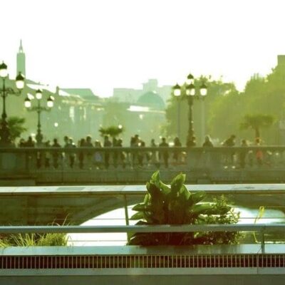 A group of people sitting on a bench near a river, enjoying the scenic views and each other's company while oblivious to any concerns about shadow banning.