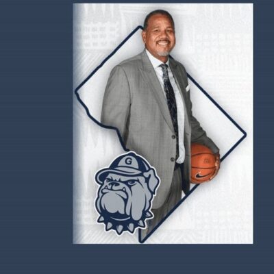 A man in a suit and tie holding a basketball.