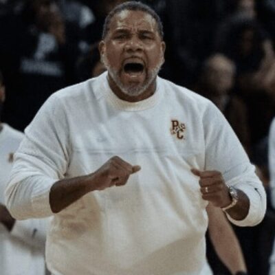 A basketball coach yelling at his team on the court.