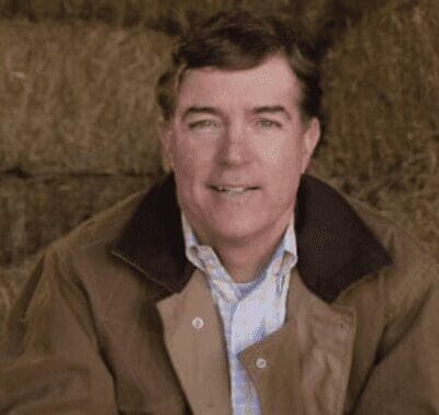 A man sitting in front of hay bales.