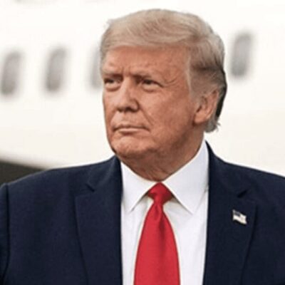President donald trump is standing in front of an airplane.