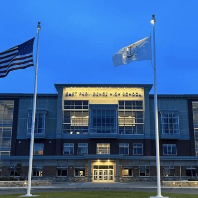 Two american flags in front of a building.
