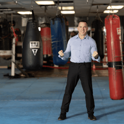 A man standing in front of a Burn with Kearns boxing ring.