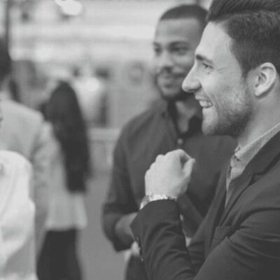 A black and white photo of a group of people talking.