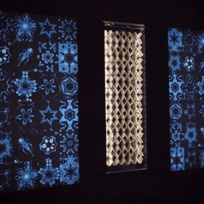 Three art panels in a dark room.