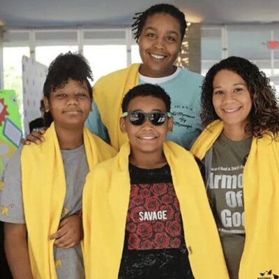 A group of people posing for a photo with yellow scarves.