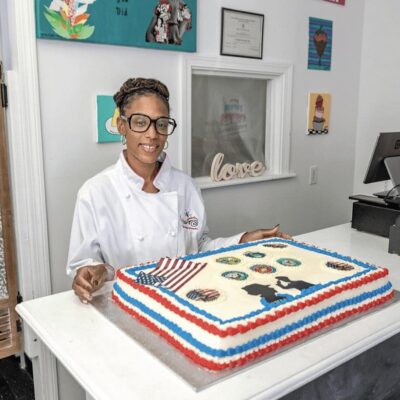 A woman standing in front of a cake.