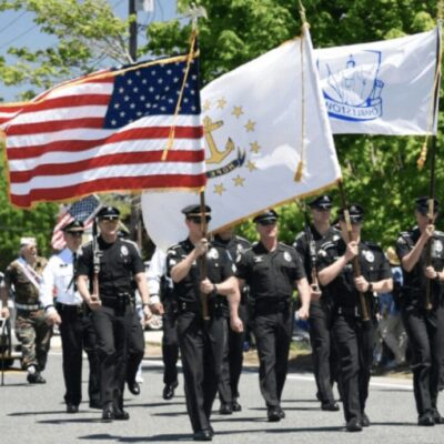 On Memorial Day, a group of police officers march down the street solemnly carrying flags to honor fallen heroes.