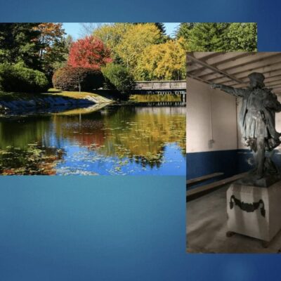 A statue of Christopher Columbus overlooking a serene pond.