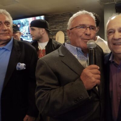 Mickey Decesare is holding a microphone.