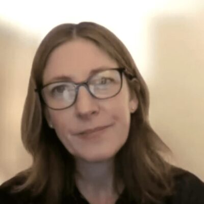 A woman wearing glasses and a black shirt.