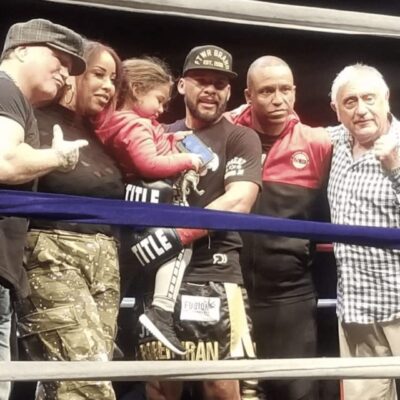 A group of people posing for a picture in a CES boxing ring.