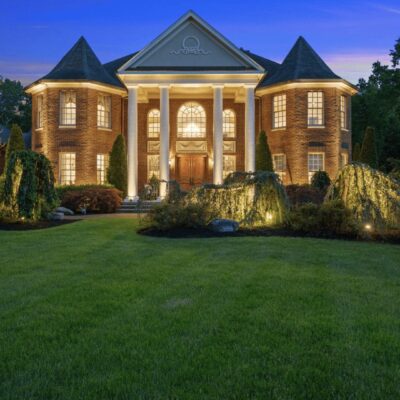 Homes for sale near me, A large brick home at dusk with a large lawn.