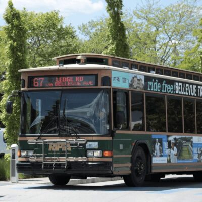 A green bus driving down the street.