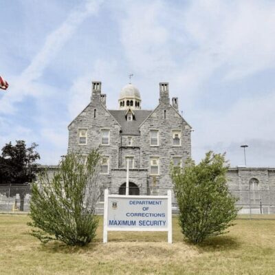A large stone building with flags in front of it, serving as a symbol of national heritage and corrections.