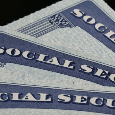 A stack of social security cards on a black background.