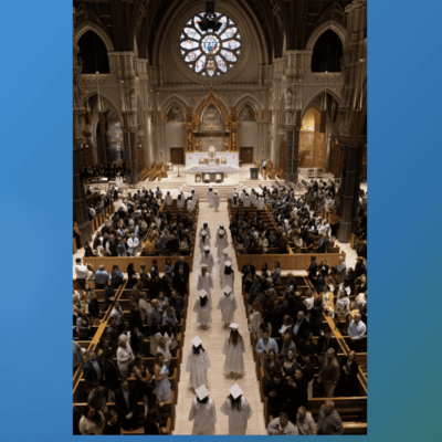 A blue and white photo of a church with people walking down the aisle.