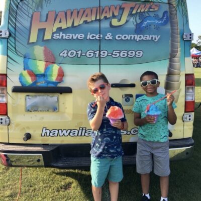 Two boys from the Fresh Air Fund standing in front of a Hawaiian ice truck.