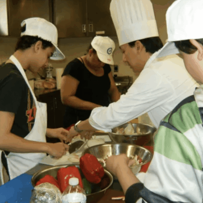 A group of homeless people preparing food in a kitchen in RI.